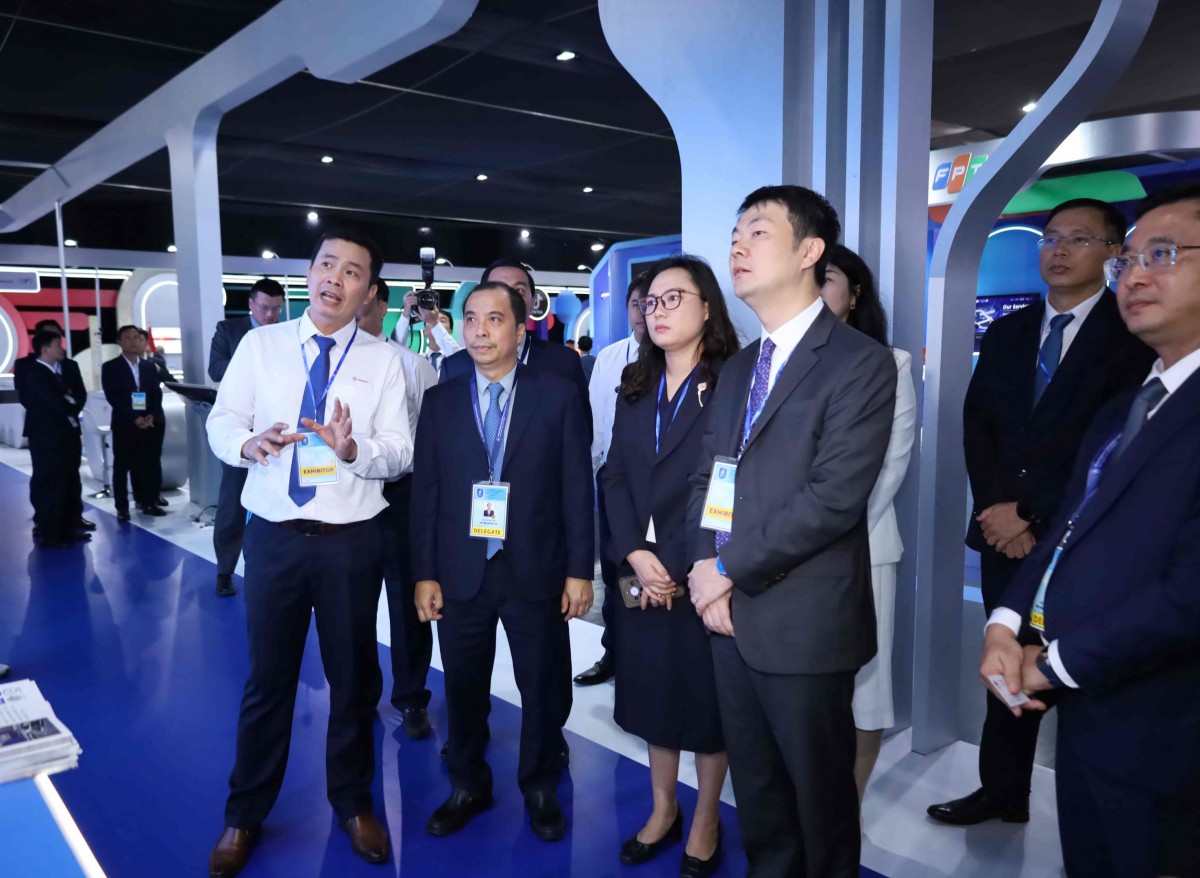 Các đại biểu trong nước, quốc tế tham quan gian trưng bày của EVN tại sự kiện Lễ mở ký Công ước Hà Nội